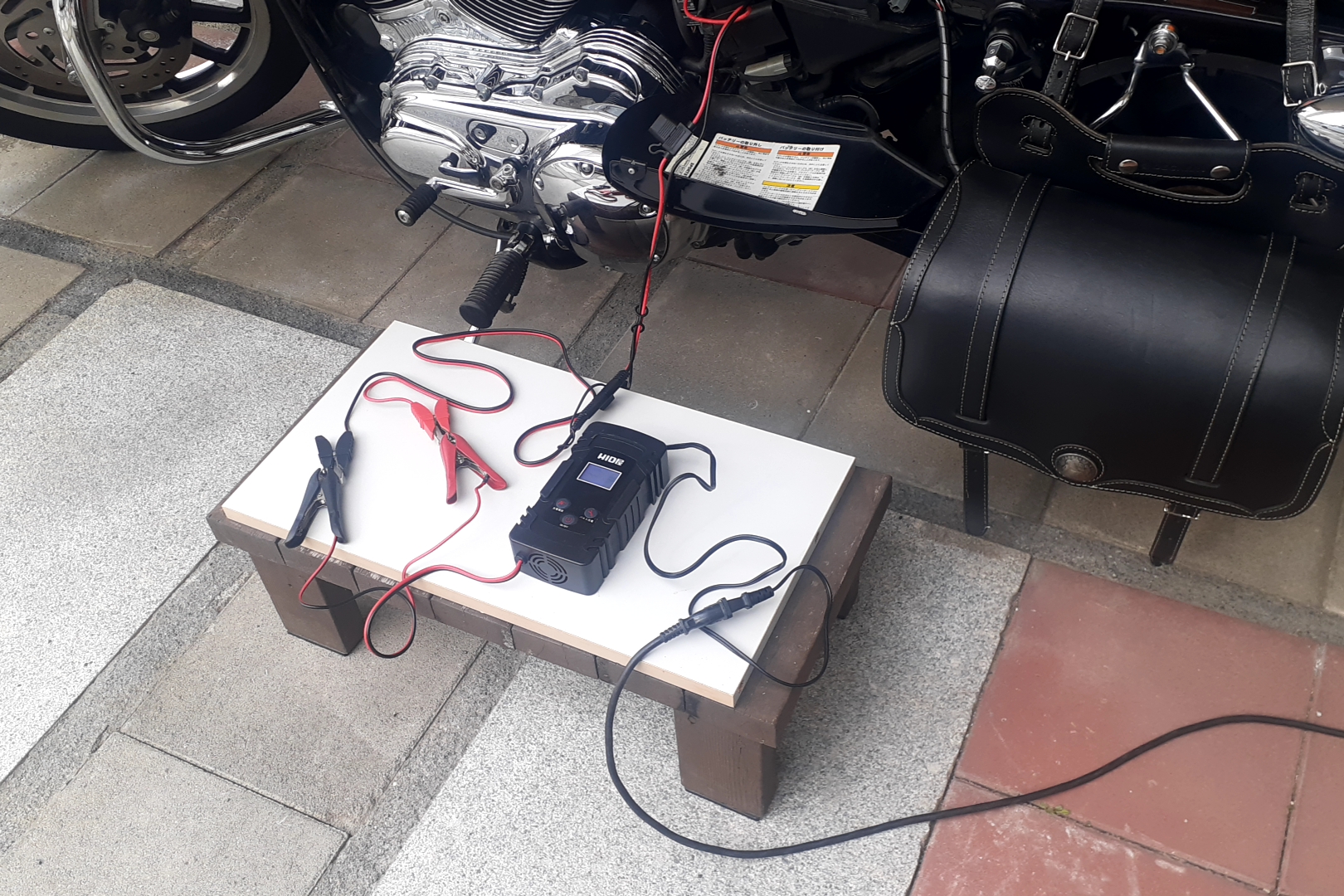 ハーレーにHID屋のバッテリー充電器BATTERY01を接続し、SEケーブルを使って自宅で充電している様子